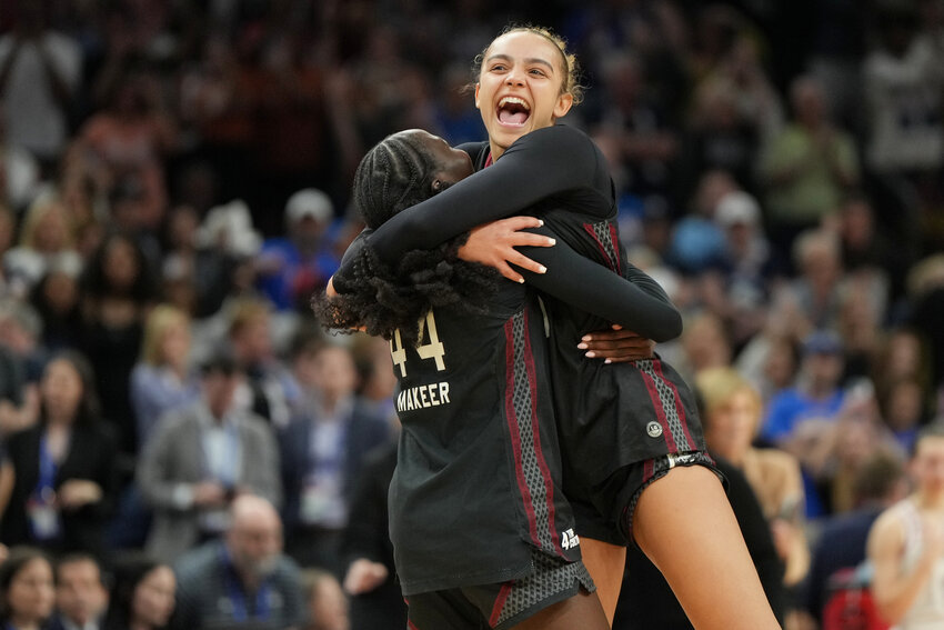 South Carolina guards Tessa Johnson, right, and Agot Makeer (44) celebrate after defeating UConn in the the Final Four of the women's NCAA tournament on Friday, April 3, 2026, in Phoenix.