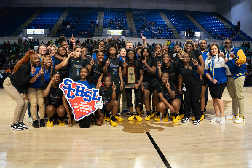 The Sumter High girls basketball team holds the trophy and SCHSL sign after winning the 2024 SCHSL 5A state championship. Sumter High will play in Region IV-5A in 2026-28.