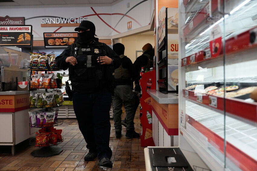 ICE agents are seen at a gas station, Monday, Jan. 19, 2026, in St. Paul, Minn.