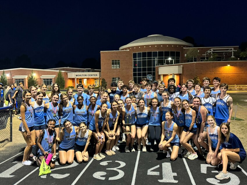 The Wilson Hall track and field team celebrates after winning both the boys and girls team titles at the SCISA Region III-4A meet on Wednesday.