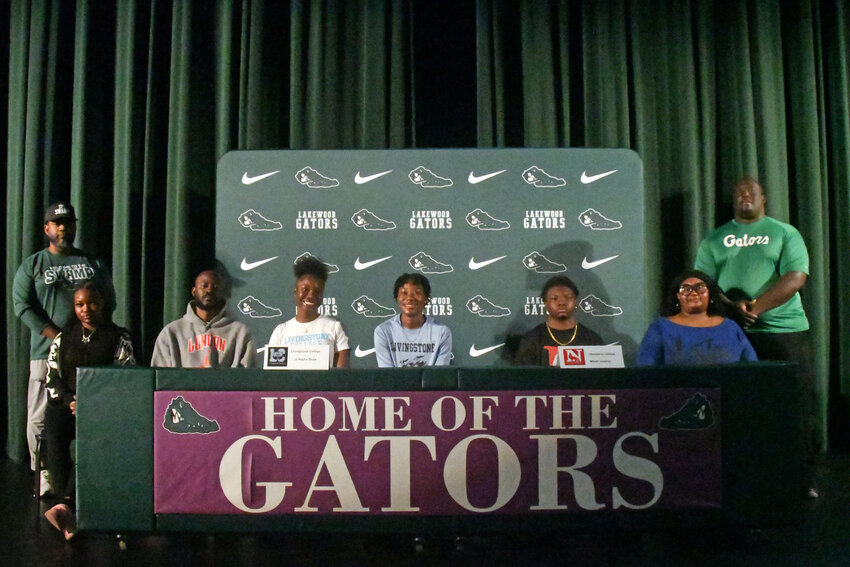 Lakewood's Ja&rsquo;Nayha Shaw, seated third from left, and Micah Jenkins, seated second from right, are joined by family and coaches after signing to continue their athletic careers in college.