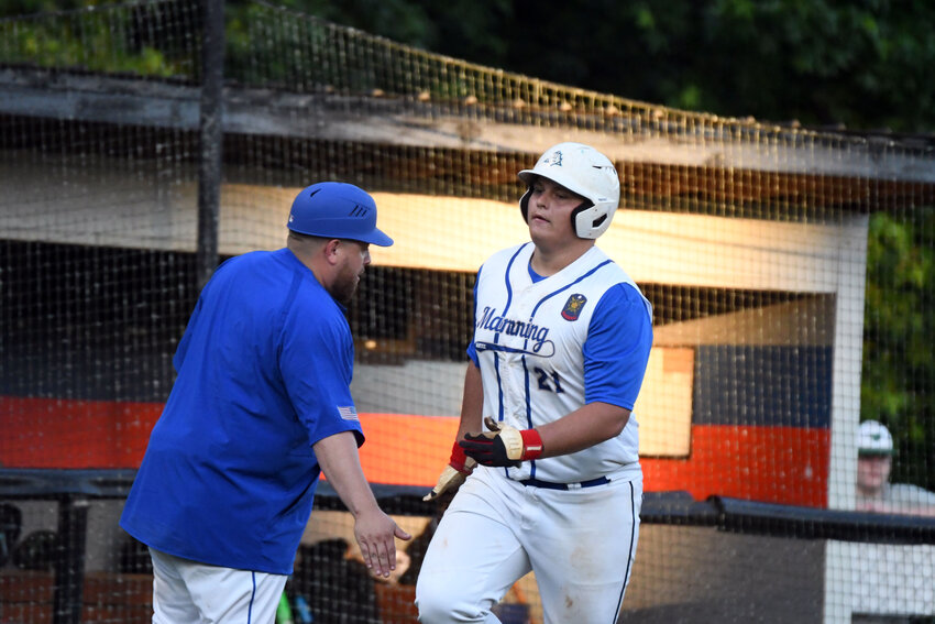 Manning-Santee's Blandyn Miller, right, high-fives head coach Greg King after hitting a solo home run against Sumter on Thursday.