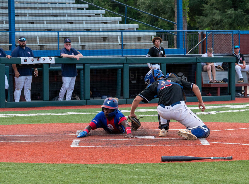 Sumter's Zy Dennis, left, slides home to score Post 15's first run in their 4-3 win over West Columbia on Monday.
