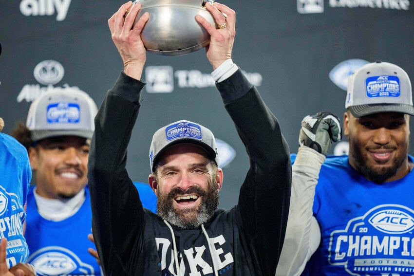 Duke head coach Manny Diaz holds up the trophy after defeating Virginia in the Atlantic Coast Conference championship on Saturday, Dec. 6, 2025, in Charlotte.