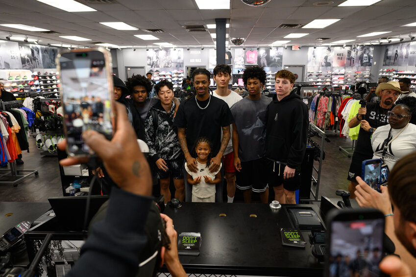 Sumter native and current Portland Trail Blazers player Ja Morant poses with his daughter and players from his Twelve Time AAU basketball team at the debut of his latest shoe at Hibbett on Saturday.