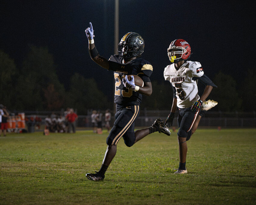 Lee Central's Jayden Burton (23) celebrates on his way into the end zone against Hannah-Pamplico on Friday.
