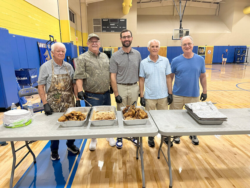 Members of the Sumter High football team receive dinner after practice. The Gamecocks are fed every weekday by a combination of Alice Drive Baptist, First Baptist, Christ Community and Grace Baptist churches and the SHS Booster Club.