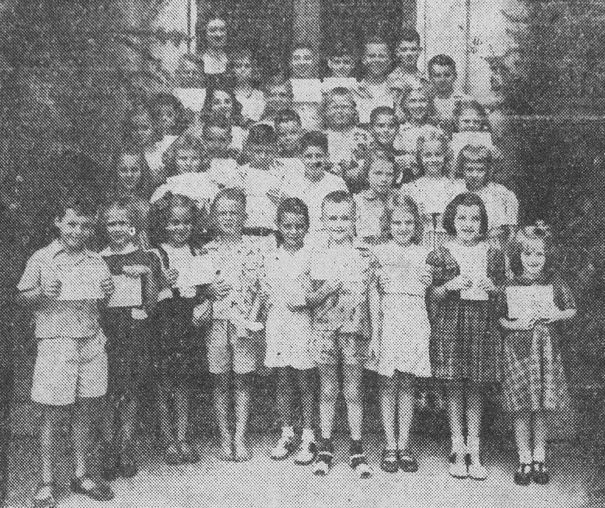 Sumter children, who were awarded certificates for having read 20 or more books during the summer months, proudly display their awards in front of Carnegie Library in September 1949. Shown with them back right is Frances Stuart, acting librarian, who originated the project.